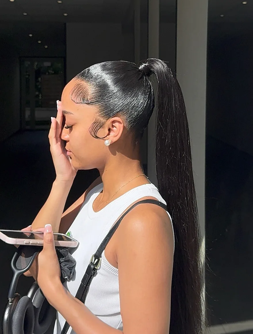 Ponylace de profil au soleil : plaquage brillant, baby hair dessinés et queue de cheval très longue